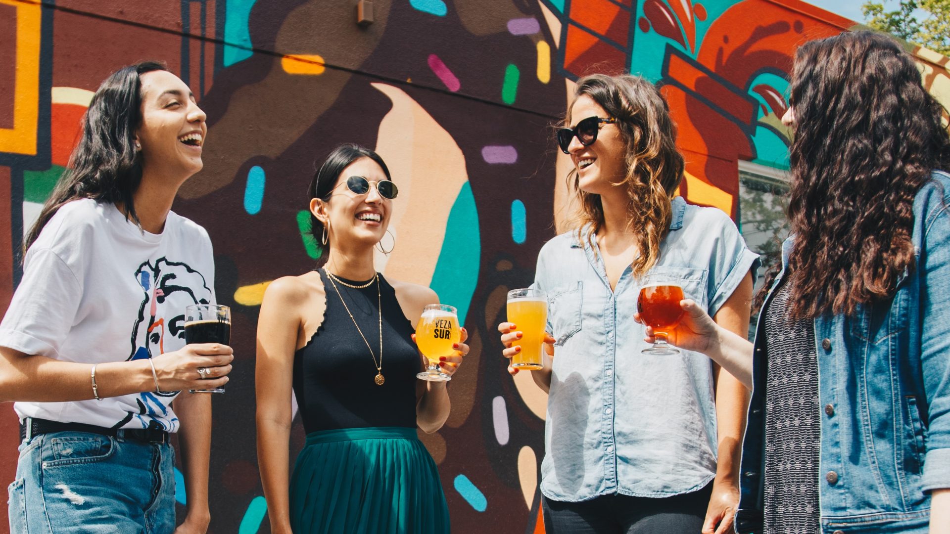 four women standing in front of a mural with beer at The Swifty Skills Session
